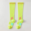 A pair of neon yellow graduated compression knee high socks with red trim.