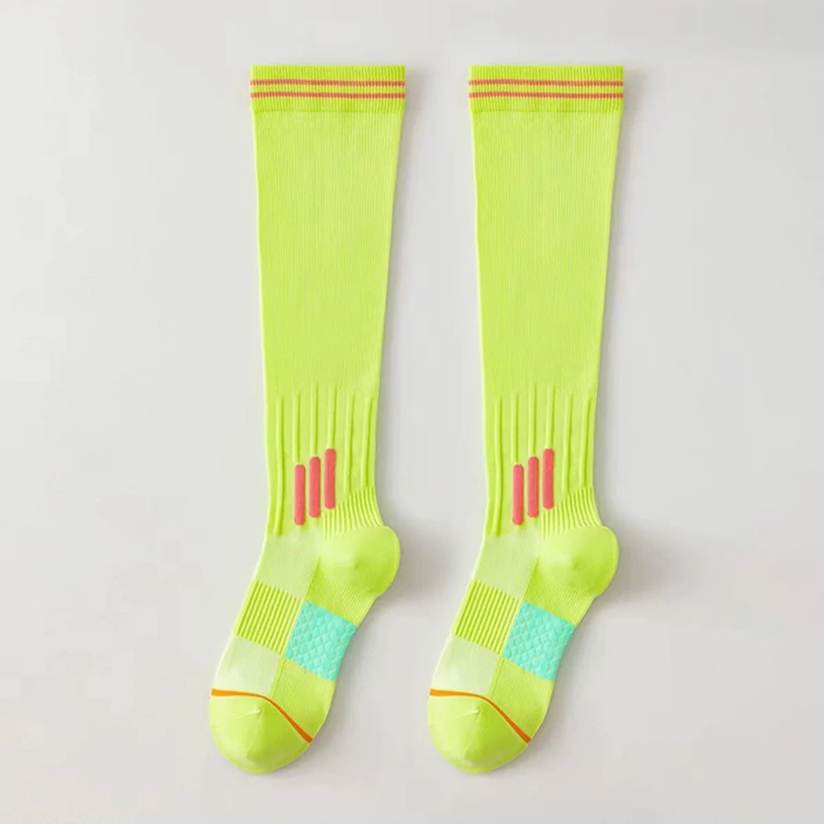 A pair of neon yellow graduated compression knee high socks with red trim.