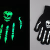 A pair of luminous green skeleton hand gloves displayed against a black background and on a white surface.