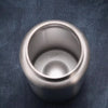 A silver stainless steel sport water bottle sitting on a dark blue fabric surface.