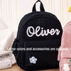 Schwarzer Cordhosen-Rucksack mit weiß besticktem Namen Oliver und einer kleinen Blumenverzierung
