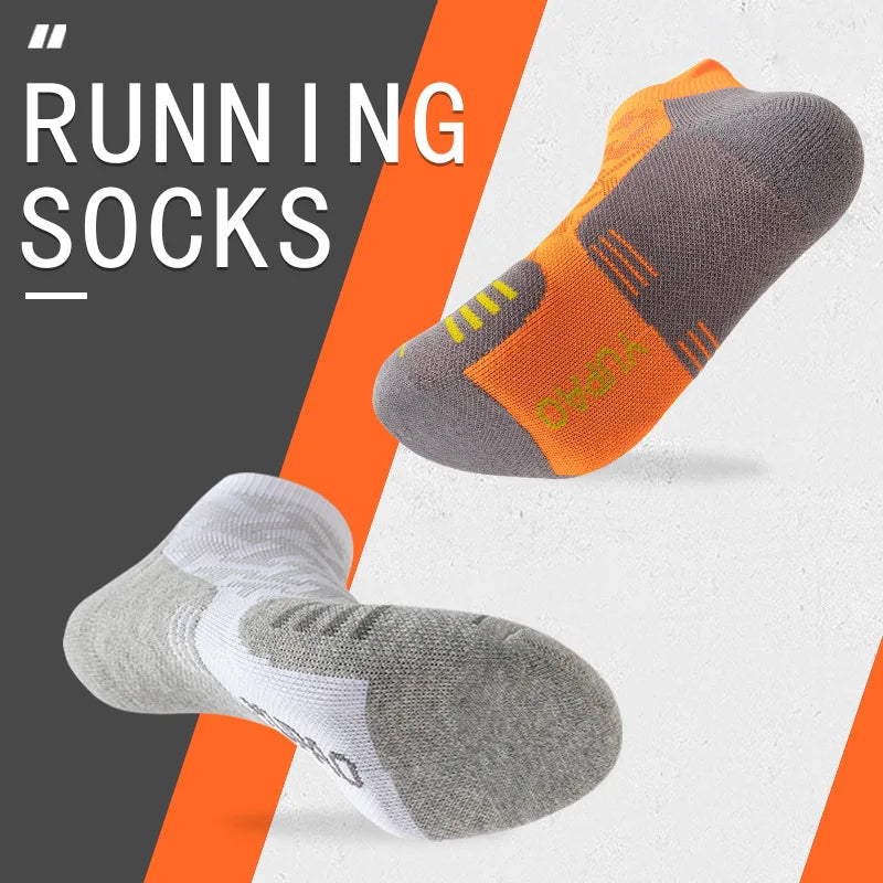 A pair of grey and orange running socks are shown against a white background.