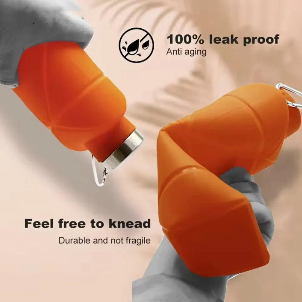 Orange silicone collapsible travel water bottle being held by a hand