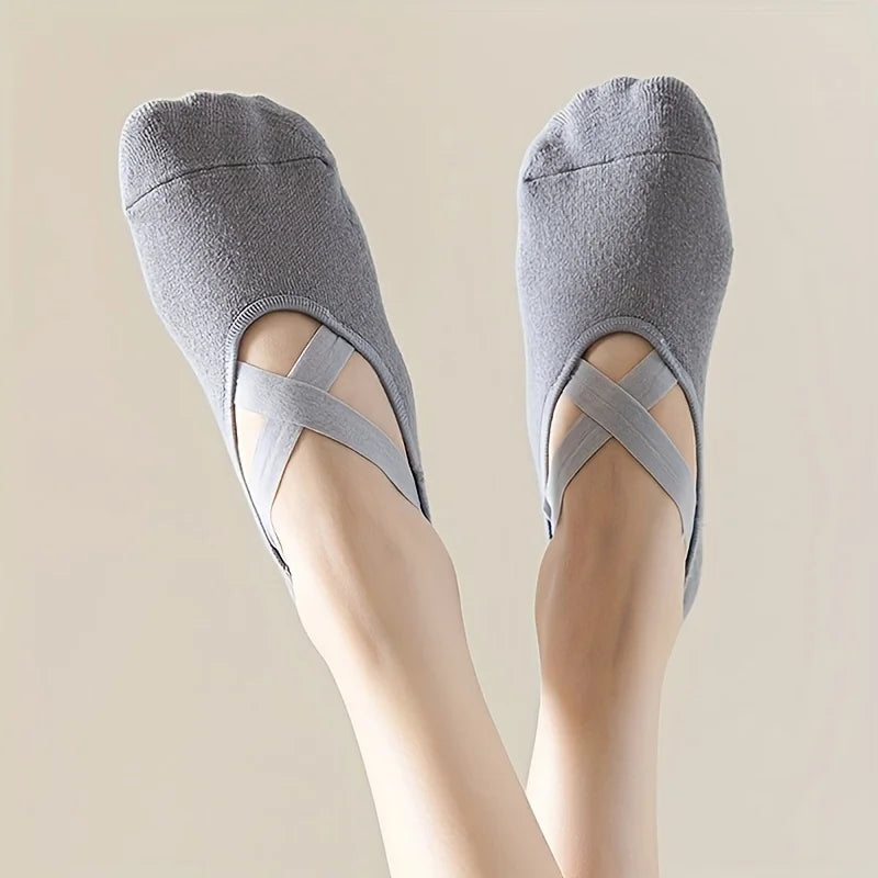 Un par de calcetines deportivos de silicona grises antideslizantes para yoga y pilates mostrados en el pie de una persona.
