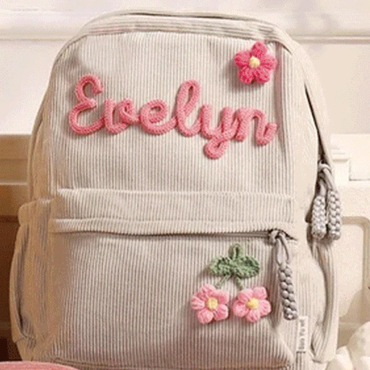 Helles beige Samtledertasche mit Namen Evelyn und rosa Blumenakzenten.