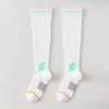 A pair of white graduated compression knee high socks with light green accents and a gray heel detail.