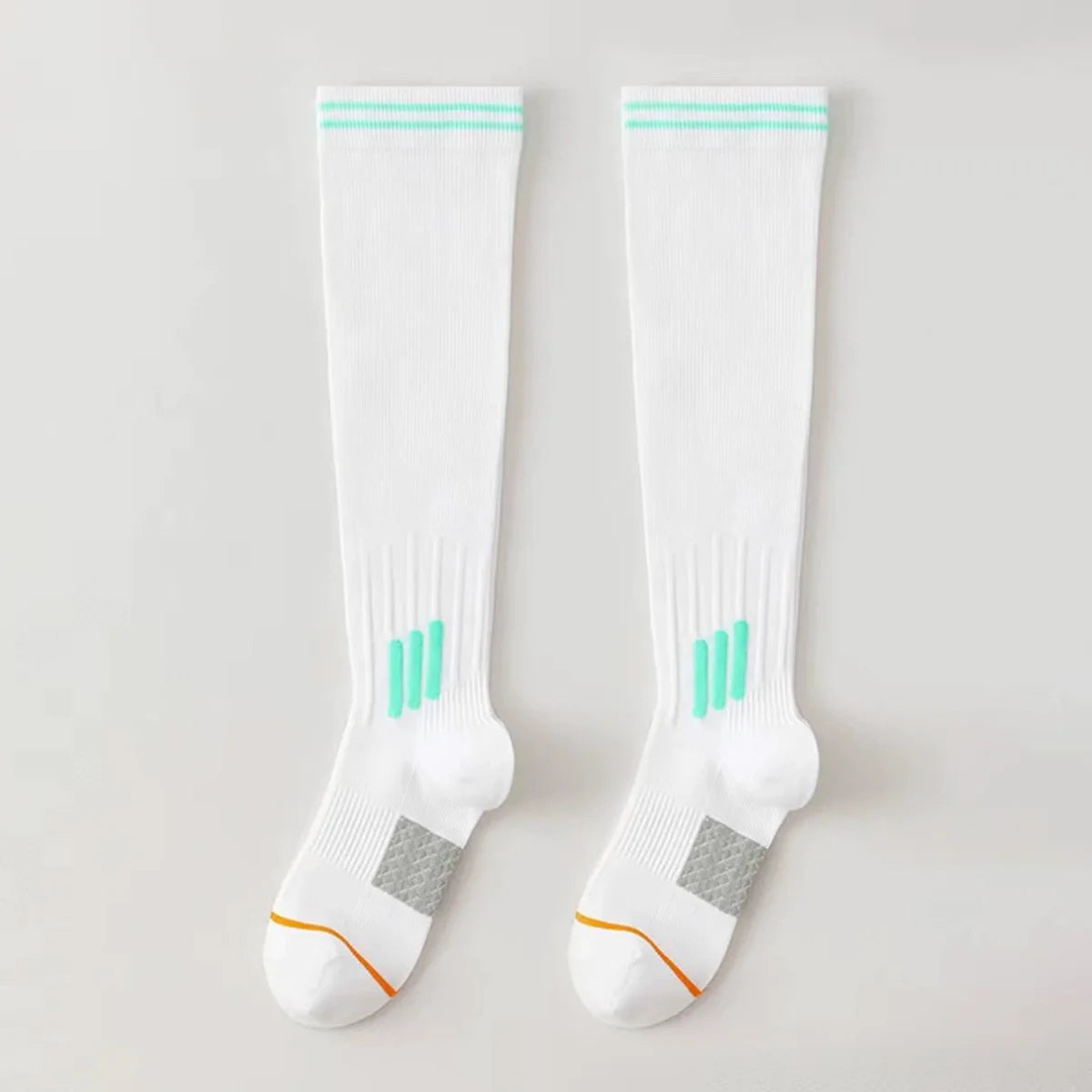 A pair of white graduated compression knee high socks with light green accents and a gray heel detail.