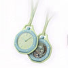 A light mint green octagonal pocket watch pendant with a silver-toned face and a pale green leather strap.