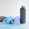 Three collapsible silicone travel water bottles in blue, purple, and gray are displayed on a light blue surface.