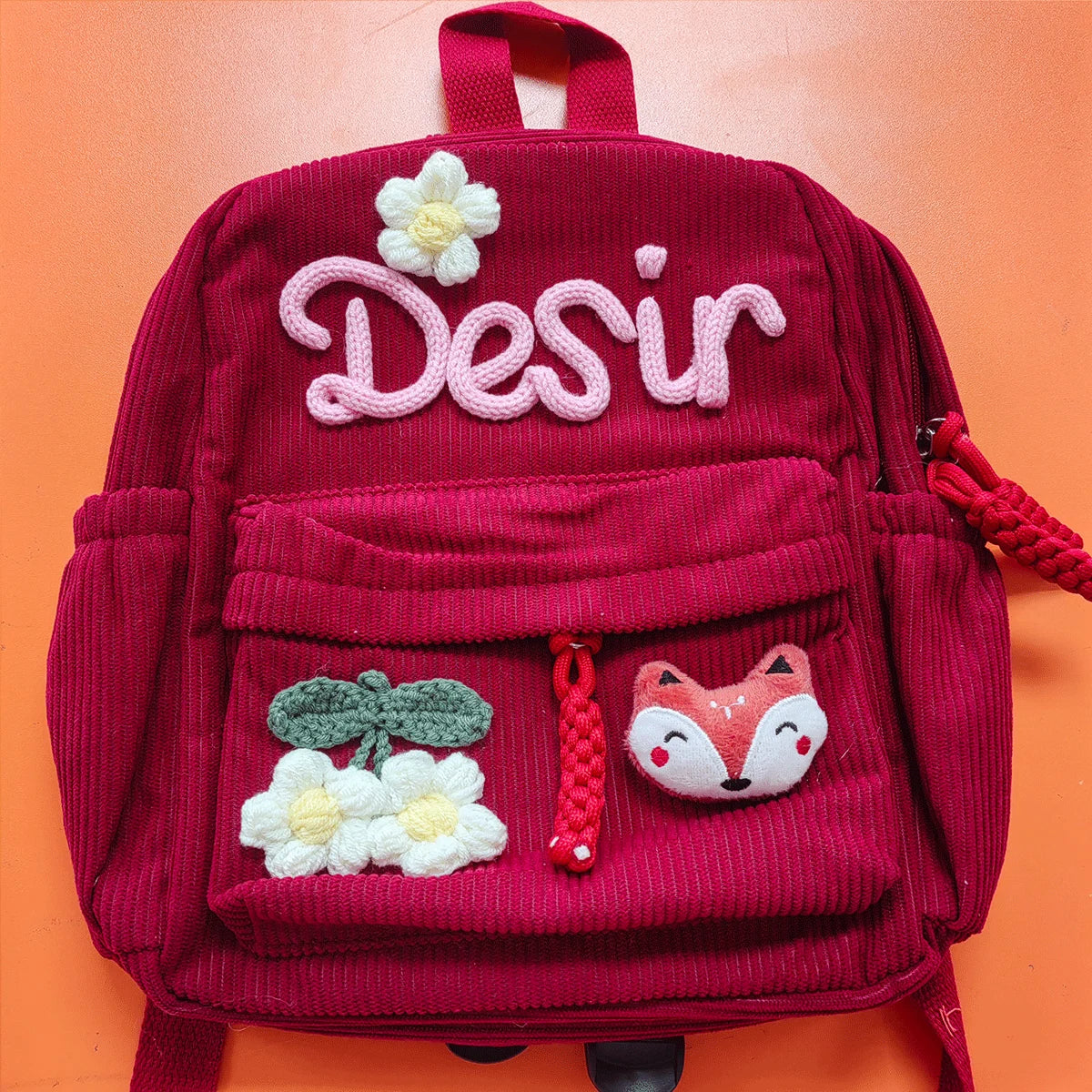 Tiefrote Cordhosen-Rucksack mit Stickerei für Desir und Motiven aus Blumen und Fuchs.