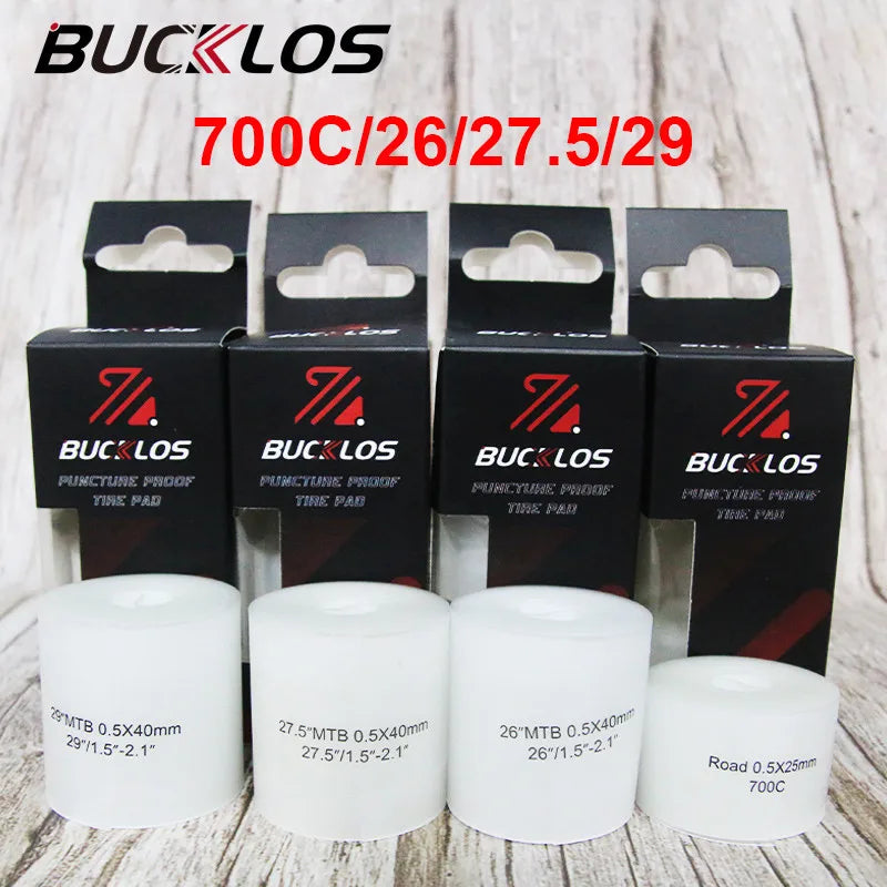 Various bicycle puncture protection liners and road tubes are displayed on a wooden surface.