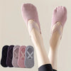 Un par de calcetines de fitness de silicona rosa antideslizantes puestos en las piernas de una persona.