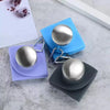 Silver collapsible silicone travel water bottle resting on blue and purple felt pads.