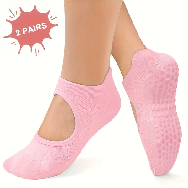 Two pairs of pink silicone yoga pilates socks shown on a person's feet.