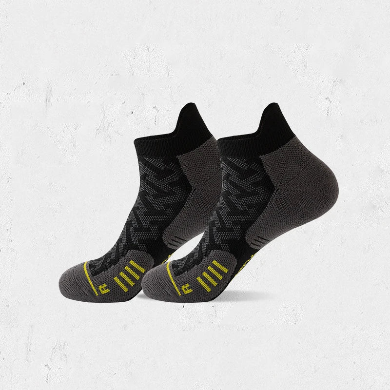 A pair of black and gray compression running socks with yellow accents displayed against a white background.