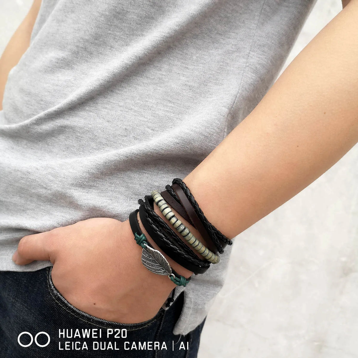 Nahaufnahme eines Handgelenks mit mehreren selbstgemachten Lederblattfeder-Armbändern.
