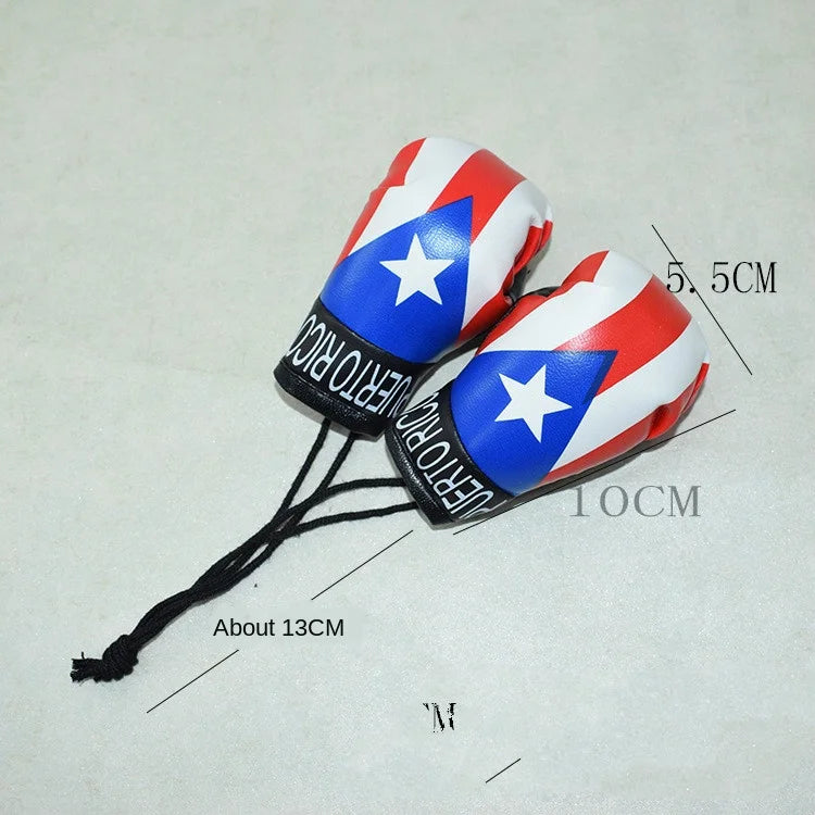 Un par de llaveros de guantes de boxeo decorativos con diseños patrióticos rojo, blanco y azul en cordón negro.