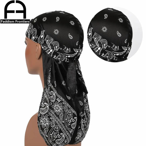 A black silk paisley durag head scarf worn by a model, showing the detailed pattern and fabric texture.