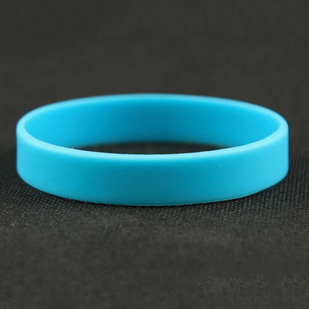A bright blue silicone elastic wristband lying on a dark surface.