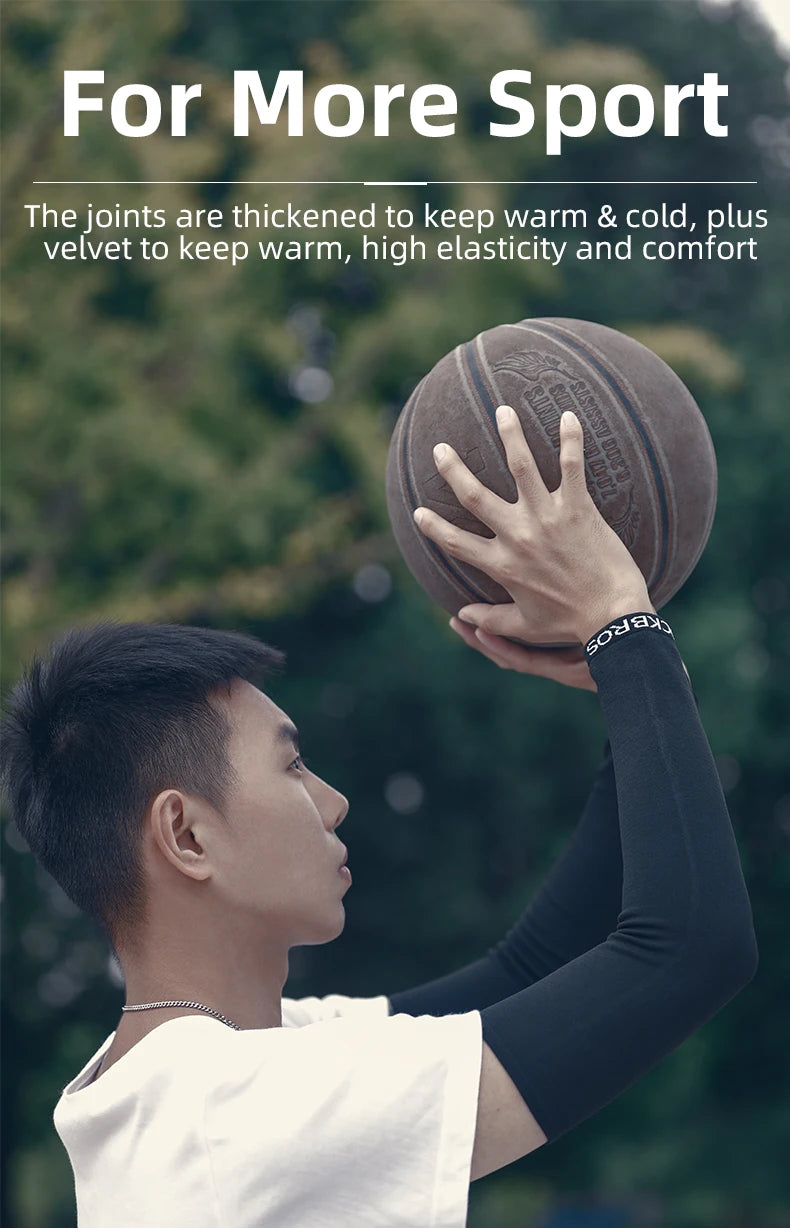 A person is holding a brown exercise ball with their hand, wearing black arm sleeves.