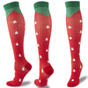 A pair of red compression socks with green cuffs and white polka dots shown from the side.