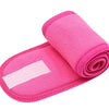 A bright pink rolled towel or headband for hair, makeup, or spa use.