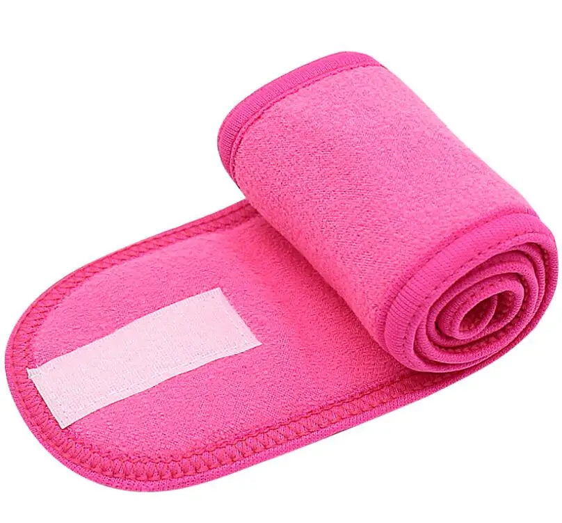 A bright pink rolled towel or headband for hair, makeup, or spa use.