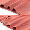 Primer plano de un short deportivo femenino sin costuras color rosa polvoriento doblado para mostrar la textura.