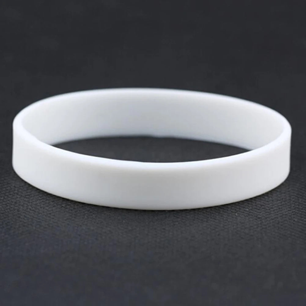 A white silicone elastic wristband lying on a dark surface.