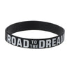 Black silicone elastic bracelet with the text Road to the Dream embossed on it.