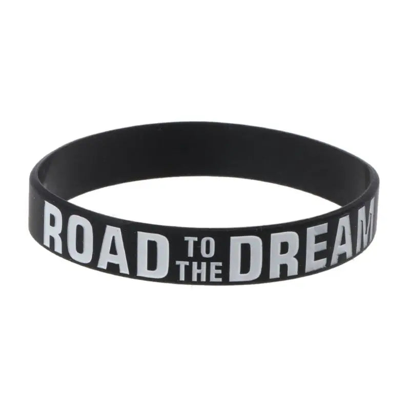 Black silicone elastic bracelet with the text Road to the Dream embossed on it.