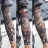 A close-up of a person wearing black and orange reusable UV protection tattoo arm sleeves on their forearm.