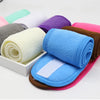 A collection of colorful, rolled-up absorbent towels and a blue headband are displayed on a white surface.
