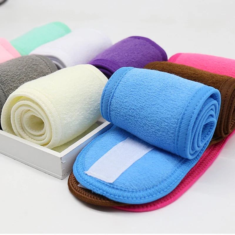 A collection of colorful, rolled-up absorbent towels and a blue headband are displayed on a white surface.