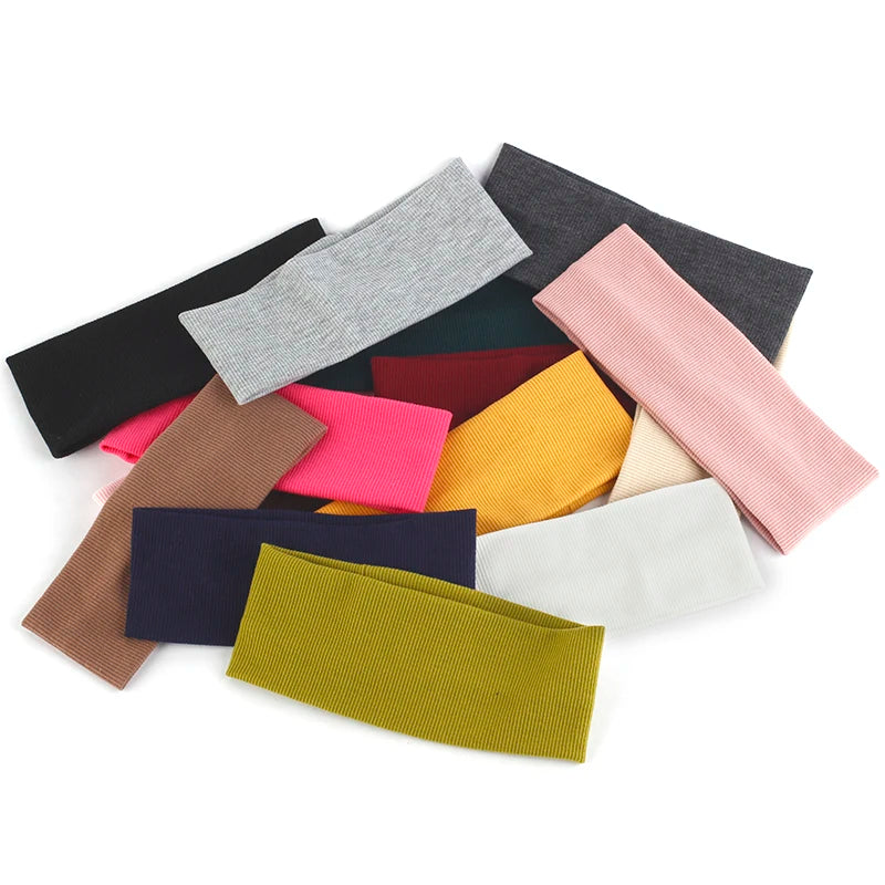 Una colección de bandas para la cabeza de algodón tejido de un solo color, mostradas sobre un fondo blanco.