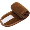 A rolled brown fabric headband with a white strip, used for hair, makeup, or spa applications.