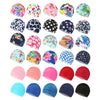 A collection of colorful elastic nylon turban swimming caps in various floral and geometric patterns.
