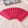 A fan of bright pink elastic headbands arranged in a semi-circle on a white fabric.