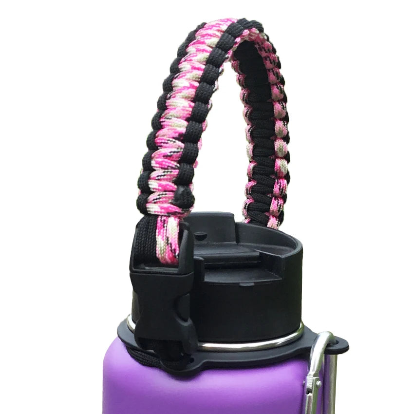 A purple water bottle with a black strap made of pink and black paracord coiled around the neck.