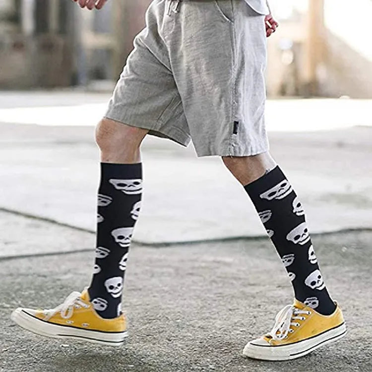 A person wearing yellow sneakers and gray shorts is shown in a side view, featuring black medical grade compression socks wit