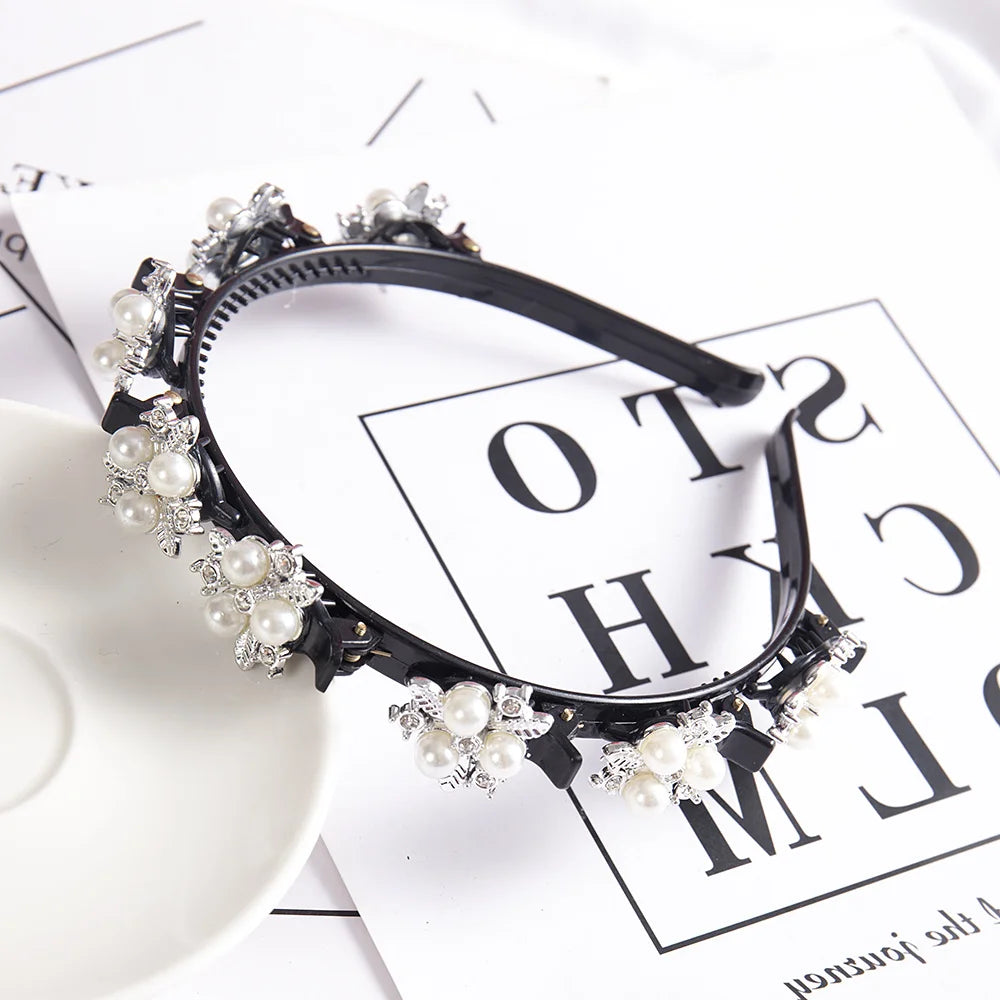 A black headband adorned with white pearls and rhinestones, displayed on a white background.