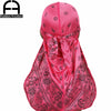 Leuchtend rosa Seidenschal mit Paisley-Muster, gebunden in einer Schleife, von hinten gezeigt.
