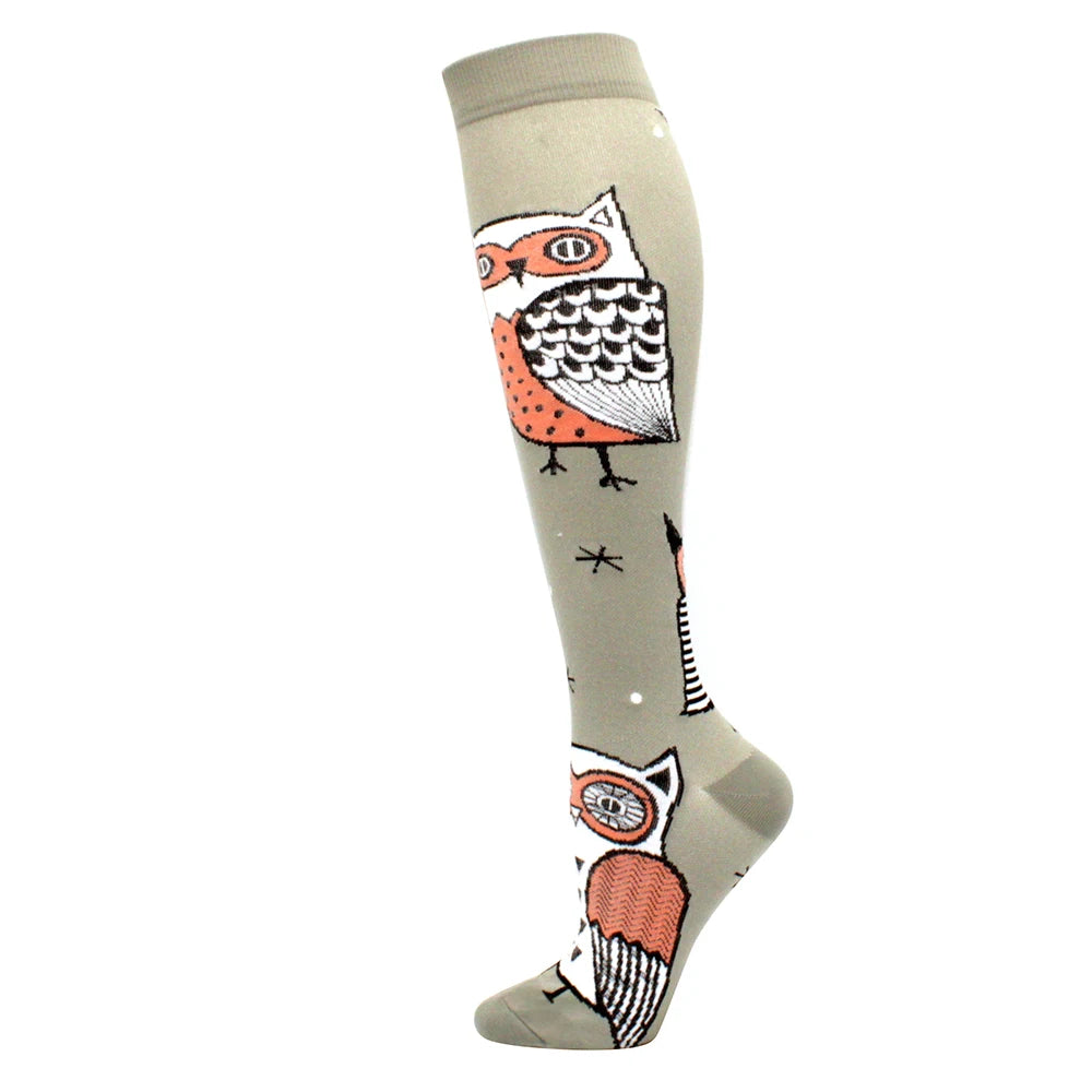A pair of light gray medical grade compression socks featuring an owl design on the foot.