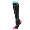 Black compression socks with a light blue cuff and yellow and green stars on the foot.