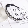 A black headband featuring a double layer design of pearls and rhinestones on a white background.