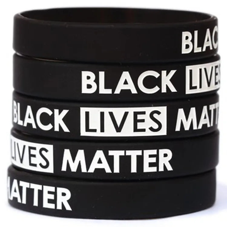 A stack of black silicone wristbands with white text reading Black Lives Matter