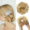 Blonde hair styled in a textured bun with silver floral extensions