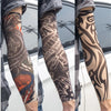 Close-up of a person wearing black and gray reusable UV protection tattoo arm sleeves on their forearm.