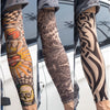 Close-up of a person wearing black and gray reusable UV protection tattoo arm sleeves on their forearm.