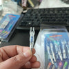 A hand holds a lighted arrow nock for archery inside its packaging.